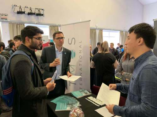 Phil Edwards and Zhuyuan Wu share insights with a student at Salford University's Career Fair
