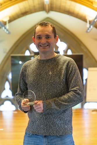 Sales and Senior Research Engineer Harry Smith with an award for his outstanding work in 2022