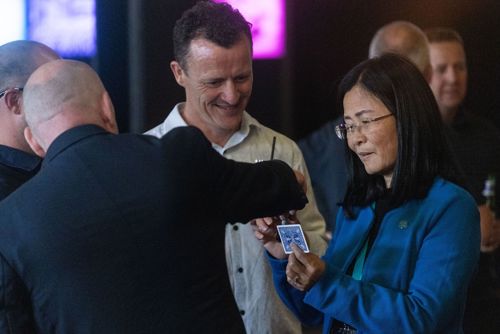 An image of Atmos' CEO and Founder Jun Zhang with User Conference attendees and a magician